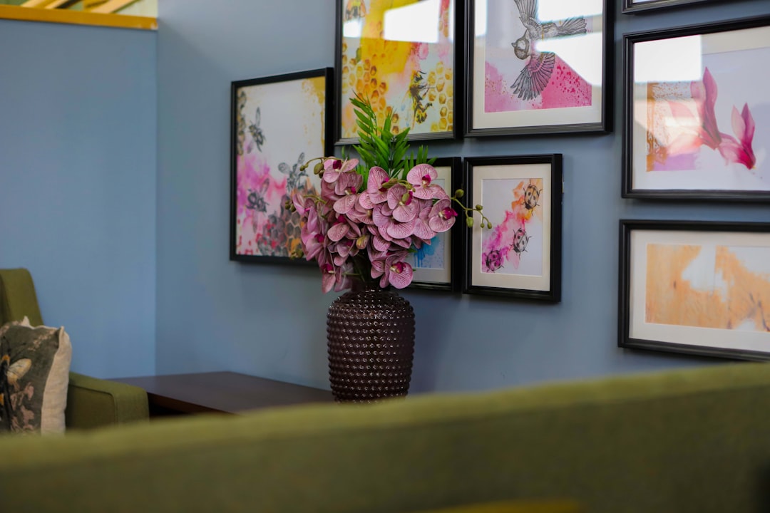 pink-flowers-in-vase-on-table-with-artwork-jn-0w-vf4y8